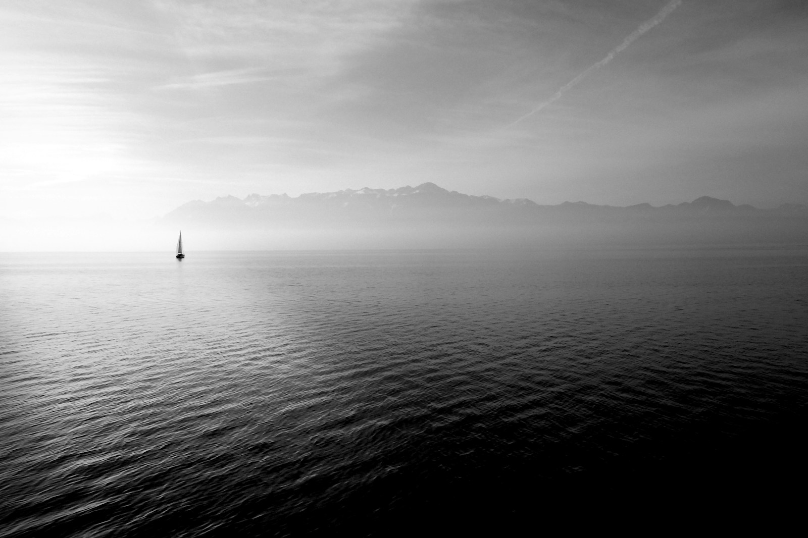 Photo by Hugo Kerr sailboat on calm body of water under white sky at daytime