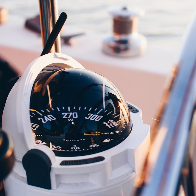 white and black compass pointing at 0 shallow focus photography
